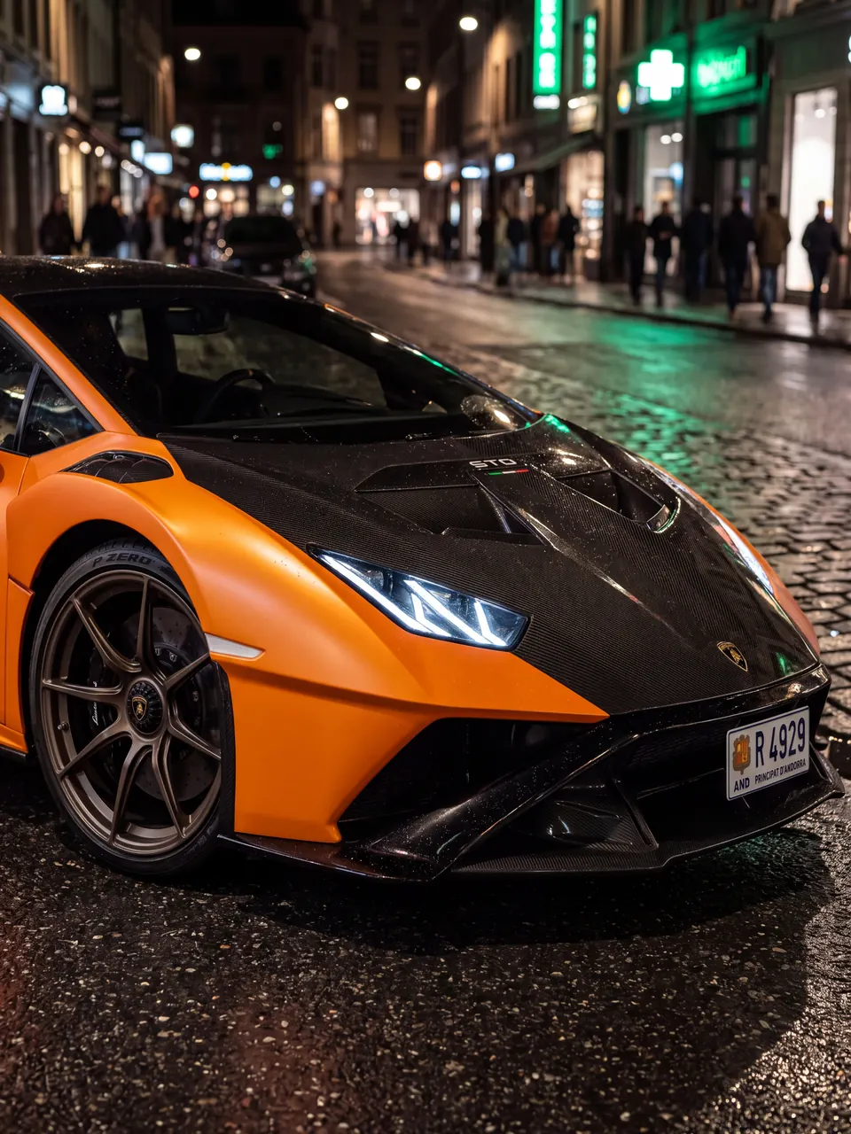 Détail de la Lamborghini Huracán STO orange de La Menace : capot carbone, phare LED et plaque andorrane